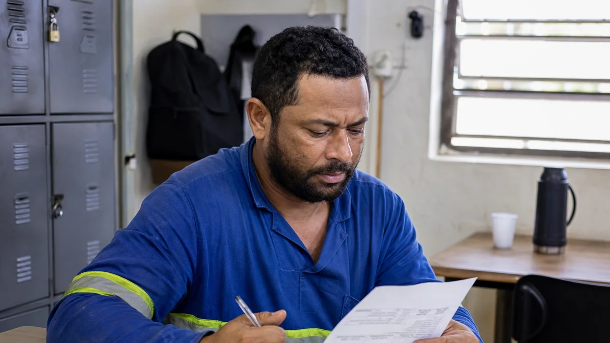 Trabalhador confere recibo discriminado de pagamento após período de trabalho intermitente